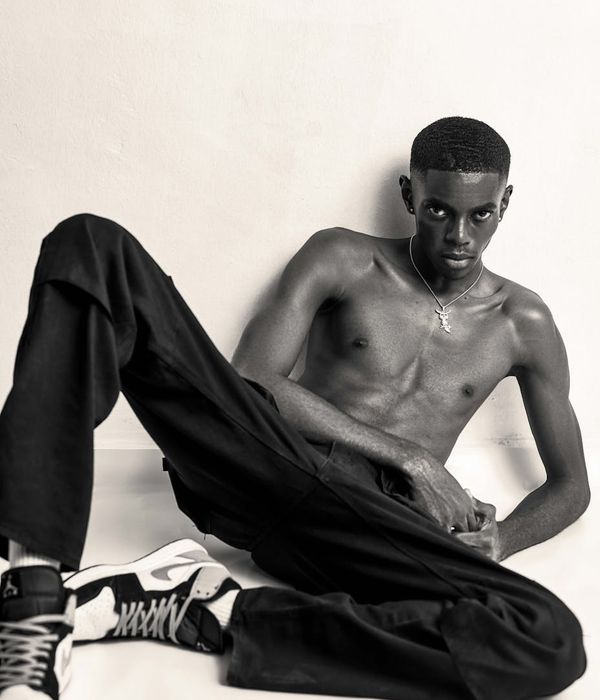 Man in a calm, focused athletic pose in a modern studio.